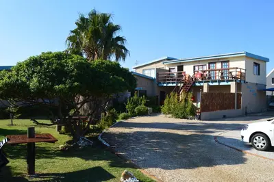 a house with a car parked in front of it at Fisherhaven Travellers Lodge in Hermanus