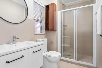 a bathroom with a toilet and a sink and a mirror at Mayfair Luxury 212 by Host Agents in Cape Town