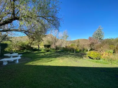 a park with a picnic table in the grass at Belle vallée Cottage in Greyton
