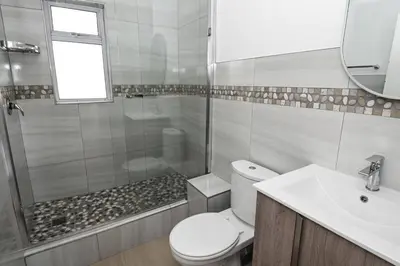 a bathroom with a shower and a toilet and a sink at 6 Culemborg Court, 5 Culemborg Street, Strand, Cape Town in Cape Town