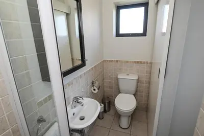 a bathroom with a toilet and a sink at 6 Culemborg Court, 5 Culemborg Street, Strand, Cape Town in Cape Town
