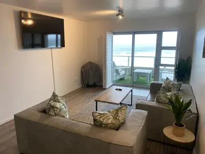 a living room with a couch and a table at Sea Spray Blouberg Beach in Bloubergstrand
