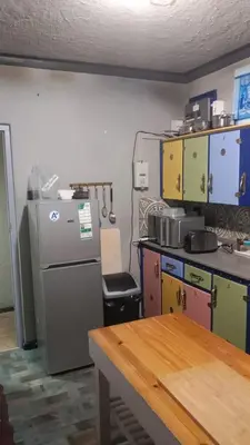 a kitchen with a refrigerator and a table at Beach Haven Sea Views, Fritzandi, Strand, Cape Town in Cape Town
