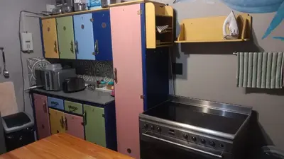a kitchen with a refrigerator and a stove at Beach Haven Sea Views, Fritzandi, Strand, Cape Town in Cape Town