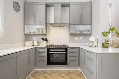 a kitchen with white cabinets and a stove top oven at Sunset Links Villa 54 in Cape Town