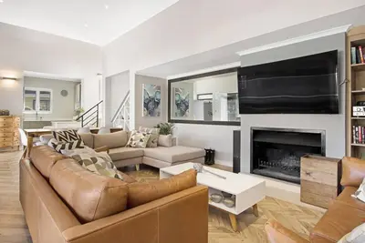 a living room with a couch and a fireplace at Sunset Links Villa 54 in Cape Town