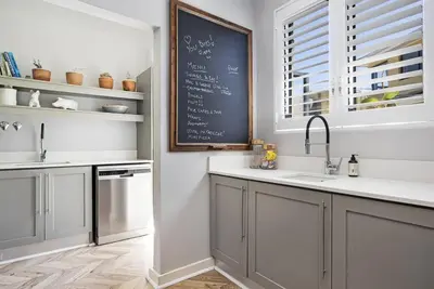 a kitchen with a chalkboard on the wall at Sunset Links Villa 54 in Cape Town