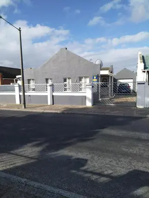 a street with a white fence and a house at Exclusive guesthouse in Cape Town