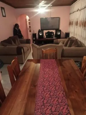 a living room with a wooden table and a couch at Exclusive guesthouse in Cape Town