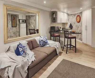 a living room with a couch and a kitchen at 10 on Gillian Self-catering Apartments - NOT AFFECTED BY LOADSHEDDING in Eversdal
