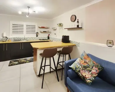 a kitchen with a counter and a blue couch at 10 on Gillian Self-catering Apartments - NOT AFFECTED BY LOADSHEDDING in Eversdal