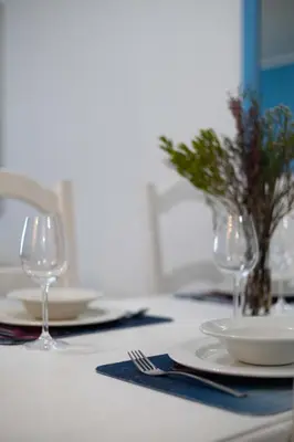 a white table with plates and glasses on it at Luxury Beach Escape Sleeps 4 - Ocean View - Spa - Pool - Gym - Back Up Power in Cape Town