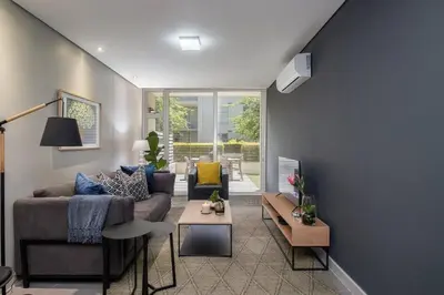 a living room with a couch and a table at Modern Family Flat Andringa Walk in Stellenbosch