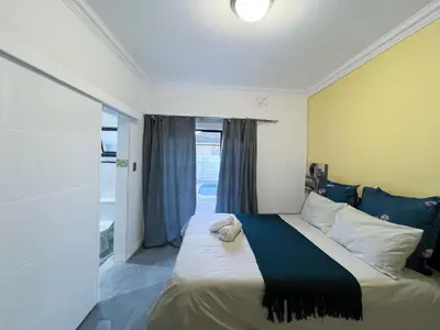 a bedroom with a large bed with a window at BOSTON HOUSE in Cape Town