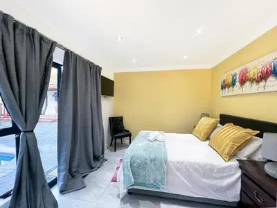 a bedroom with a bed and a window at BOSTON HOUSE in Cape Town