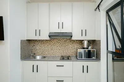 a white kitchen with a sink and a microwave at BOSTON HOUSE in Cape Town