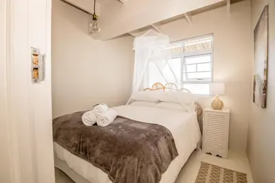 a bedroom with a bed with two towels on it at Klein Paradys in Kleinmond