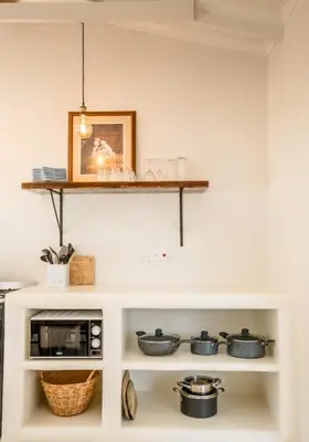 a kitchen with a shelf above a microwave at Klein Paradys in Kleinmond