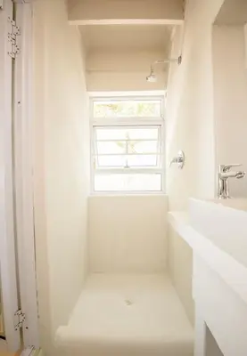 a white bathroom with a sink and a window at Klein Paradys in Kleinmond