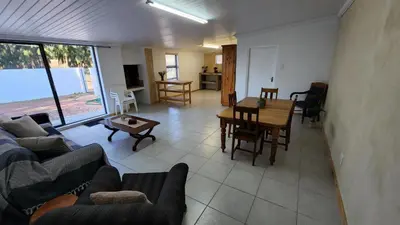 a living room with a couch and a table at Sandrivier Farm Stay in Worcester