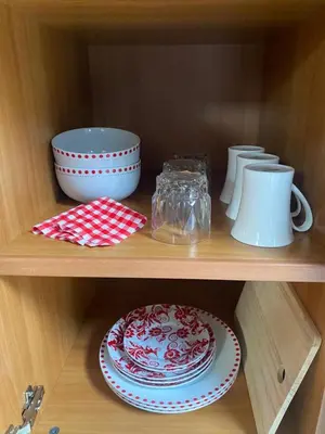 a wooden shelf with plates and bowls on it at Big room in Stellenbosch in Stellenbosch