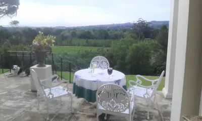 a table and chairs on a patio with a view at Morton Manor in Somerset West
