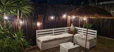 a patio with a couch and an umbrella at Apartment with garden in Cape Town