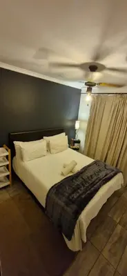 a bedroom with a bed with two towels on it at Apartment with garden in Cape Town