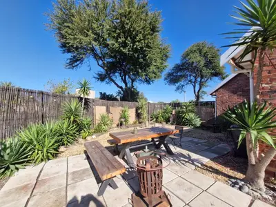 a wooden picnic table and bench in a garden at Apartment with garden in Cape Town