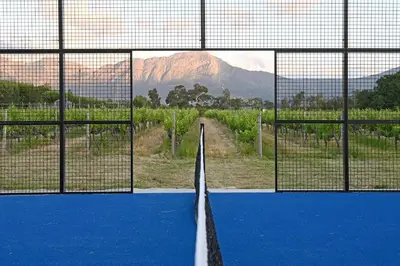 a tennis court with a view of a mountain at Fransvliet Guest House in Franschhoek