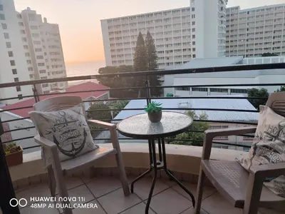 a balcony with a table and chairs on a balcony at Nautica Strand in Cape Town