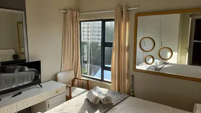 a bedroom with a large mirror and a large window at Nautica Strand in Cape Town
