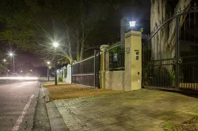 a street at night with a fence and street lights at 10 Alexander B&B in Stellenbosch