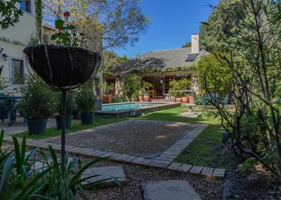 a garden with a house and a pool at 10 Alexander B&B in Stellenbosch