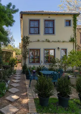a house with a table and chairs in a yard at 10 Alexander B&B in Stellenbosch