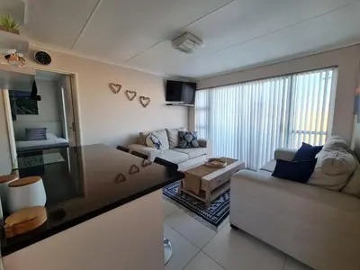 a living room with a couch and a table at Hermanus Beach Club UNIT 74 in Hermanus