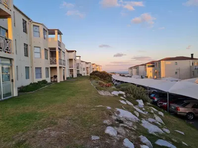 a row of apartment buildings with cars parked next to them at Hermanus Beach Club UNIT 74 in Hermanus