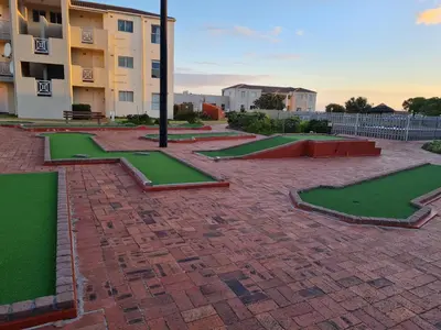 a brick courtyard with green grass in front of a building at Hermanus Beach Club UNIT 74 in Hermanus