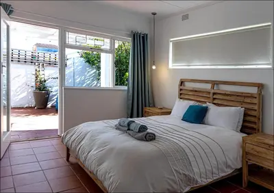 a bedroom with a bed and a large window at SeaCrest Cottage in Hermanus