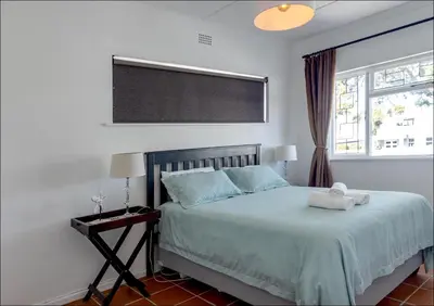 a bedroom with a bed and a window at SeaCrest Cottage in Hermanus