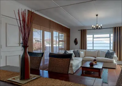 a living room with a white couch and a vase at SeaCrest Cottage in Hermanus