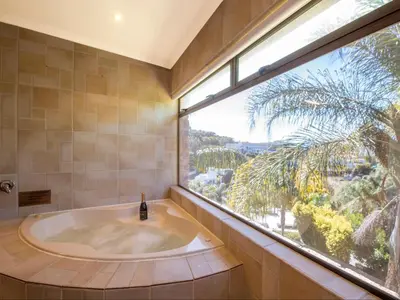 a bath tub in a bathroom with a large window at Aan de Paarlberg in Paarl