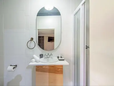 a bathroom with a sink and a mirror at Aan de Paarlberg in Paarl