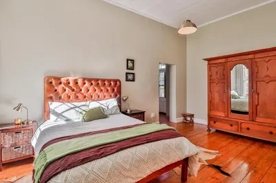 a bedroom with a large bed and a dresser at Twistniet BnB in Wellington