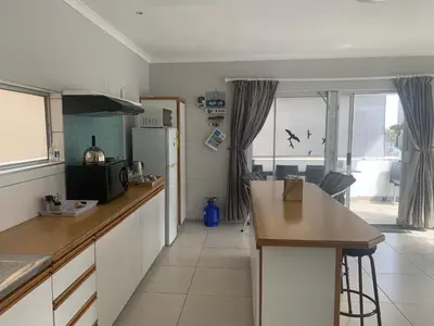 a kitchen with a counter top and a refrigerator at OysterCatcher Self-Catering Accommodation Strand in Cape Town