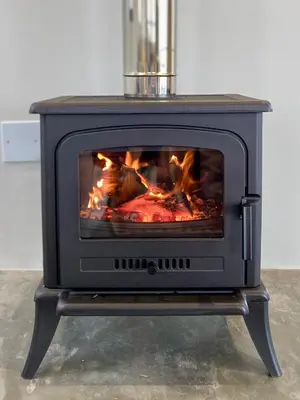 a stove with a fire inside of it at Sneeukop Mountain Cottage in Paarl