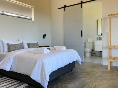 a bedroom with a bed with two towels on it at Sneeukop Mountain Cottage in Paarl