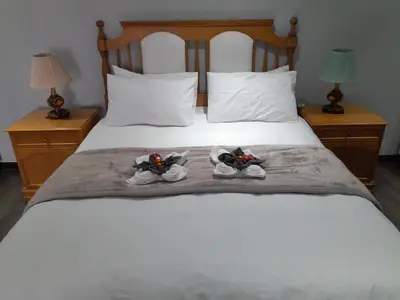 two pairs of shoes sitting on top of a bed at Magnolia Cottage in Cape Town