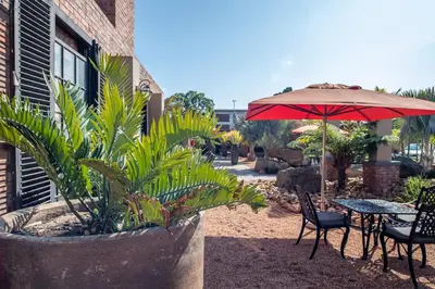 a patio with an umbrella and a table and chairs at Excellent Guest House in Bellville