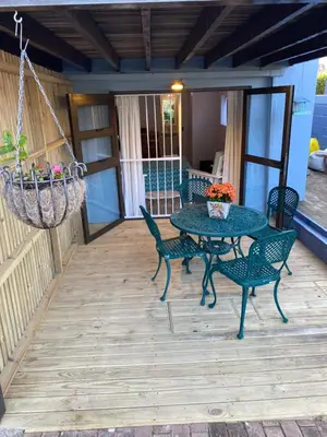 a patio with a table and chairs and a chandelier at Self Catering Luke Drive Onrus in Hermanus